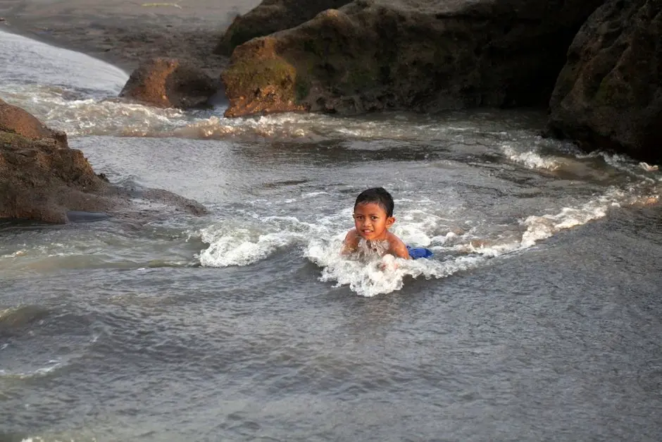 Anak-anak bermain di pantai berbatu putih Pulau Penyengat